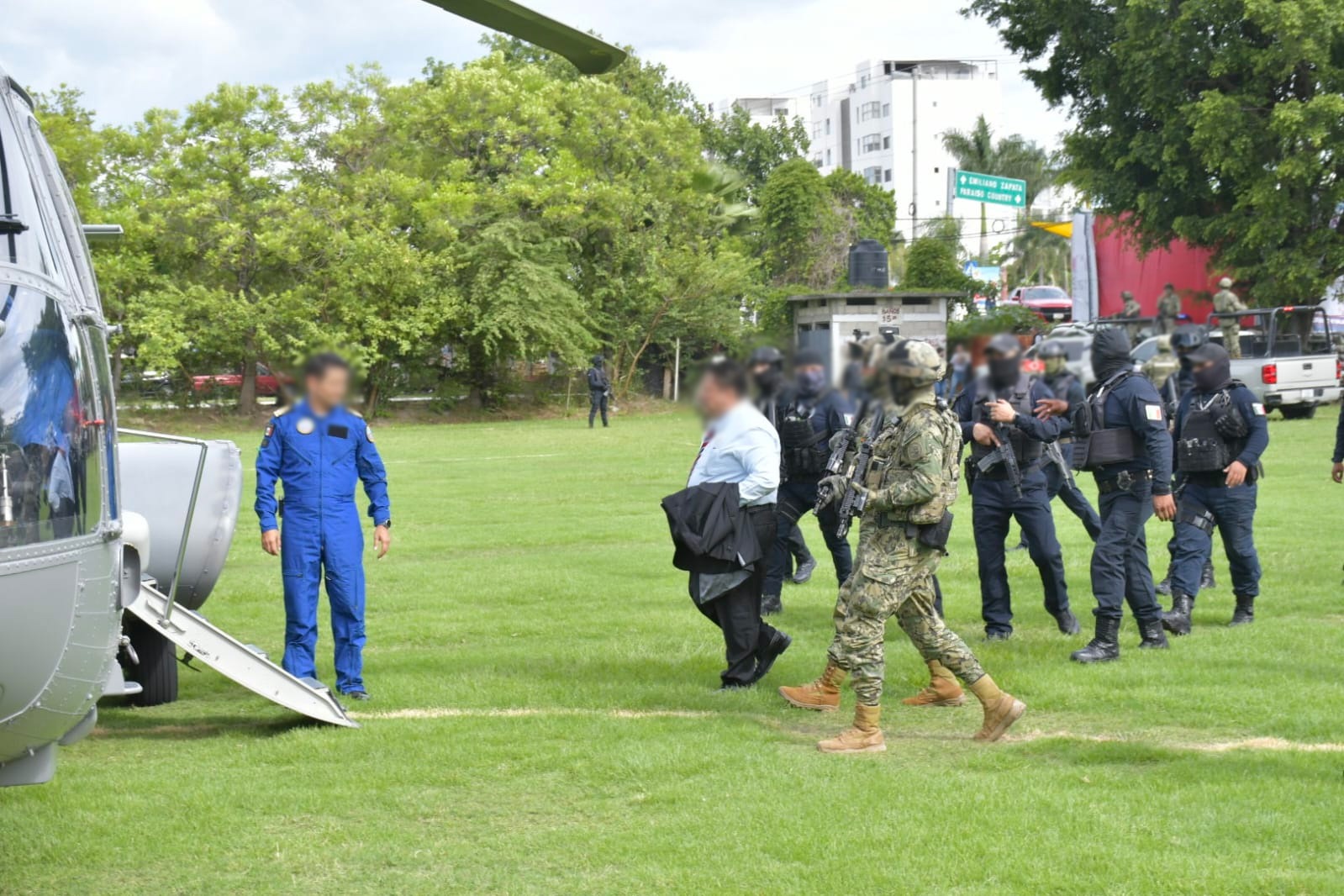 Un grupo de personas de pie sobre pasto Descripción generada automáticamente