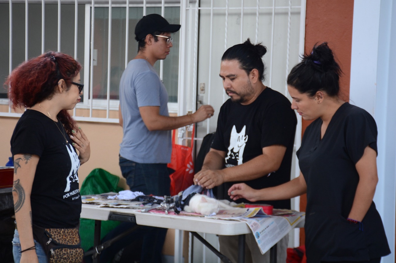 Un grupo de personas frente a un pastel Descripción generada automáticamente