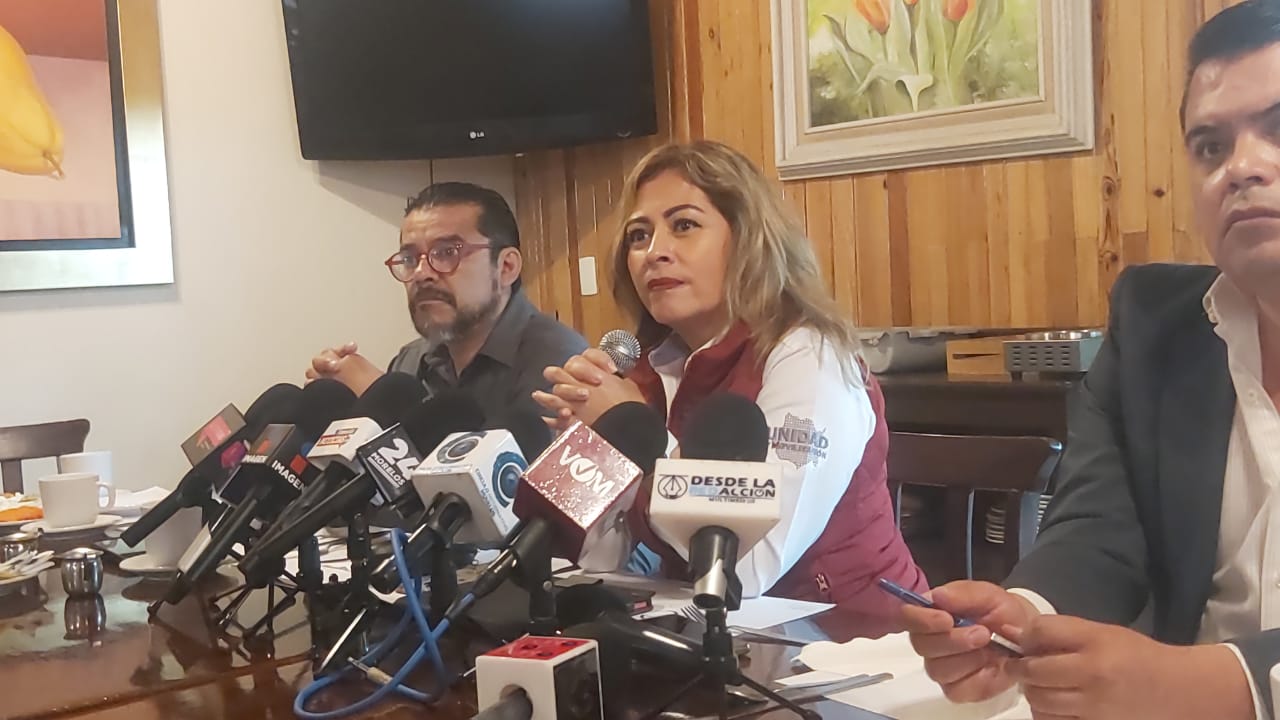 Un par de personas sentadas en una mesa Descripción generada automáticamente