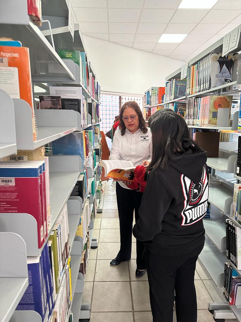 Mujer parada enfrente de una tienda Descripción generada automáticamente
