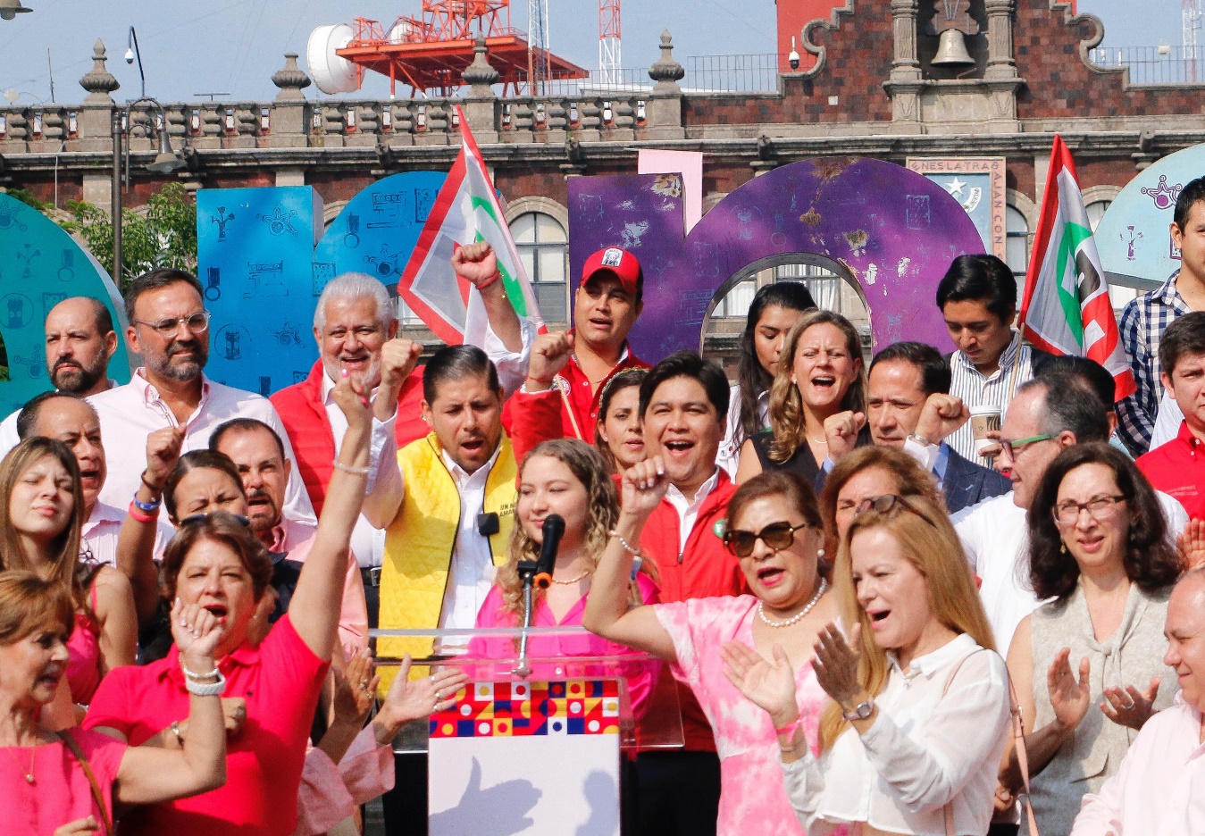 Un grupo de personas posando delante de una multitud de gente Descripción generada automáticamente