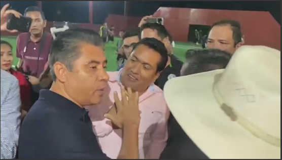 Un par de hombres sentados en una mesa Descripción generada automáticamente con confianza baja