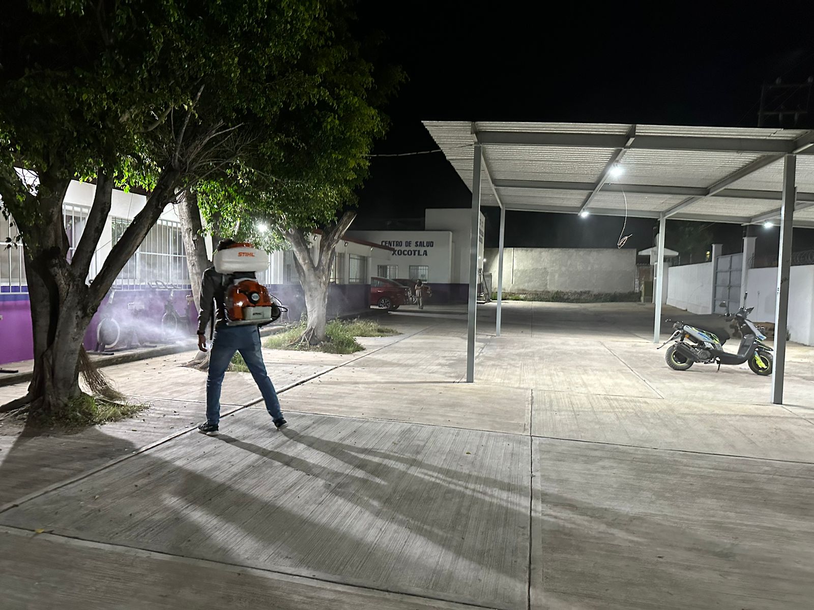 Una persona caminando con una sombrilla en la calle Descripción generada automáticamente con confianza media