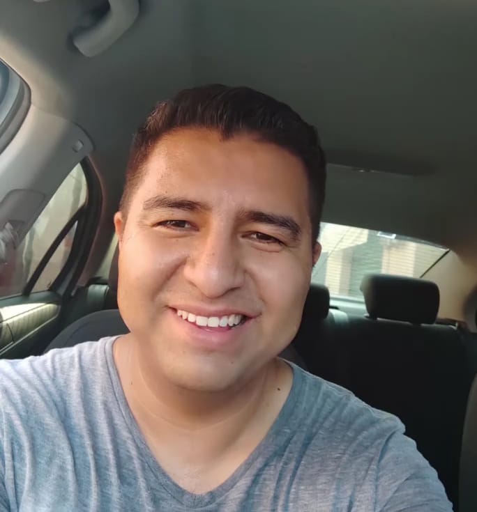 Un joven sentado en el asiento de un coche Descripción generada automáticamente