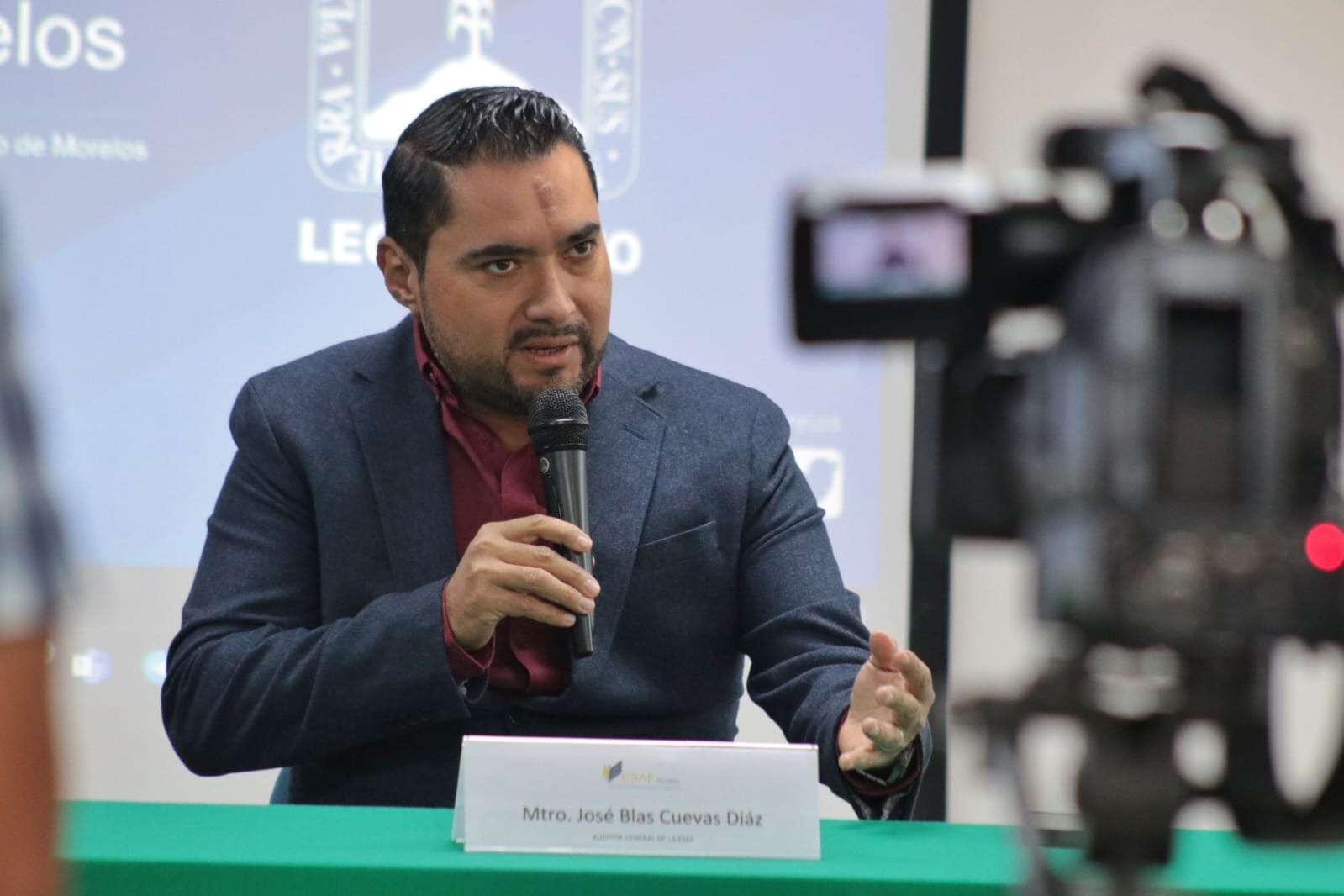 Un hombre con un micrófono en la mano Descripción generada automáticamente con confianza baja