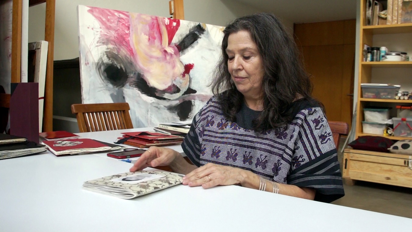 Mujer sentada en un escritorio Descripción generada automáticamente con confianza media