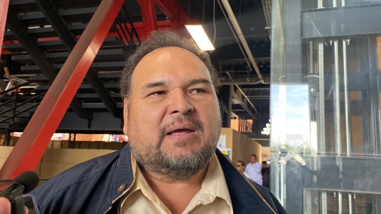 Hombre sonriendo en frente de un edificio Descripción generada automáticamente