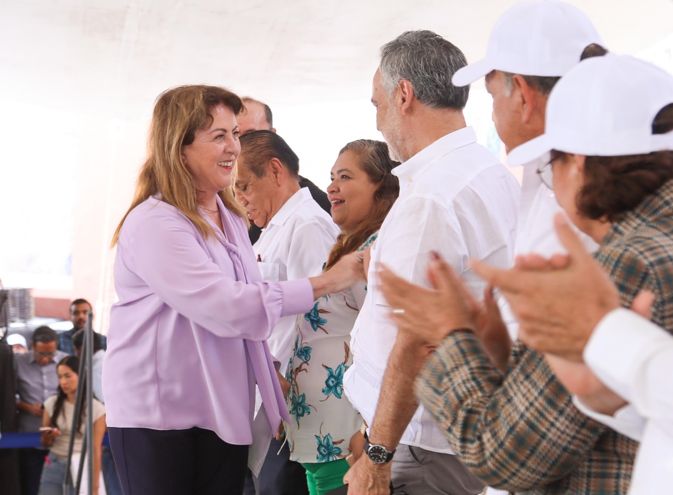 Un grupo de personas de pie Descripción generada automáticamente con confianza media