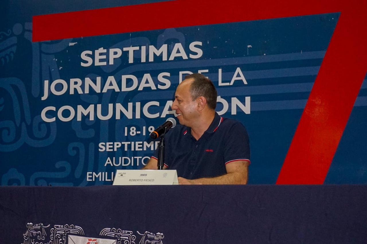 Un hombre con un micrófono Descripción generada automáticamente con confianza baja