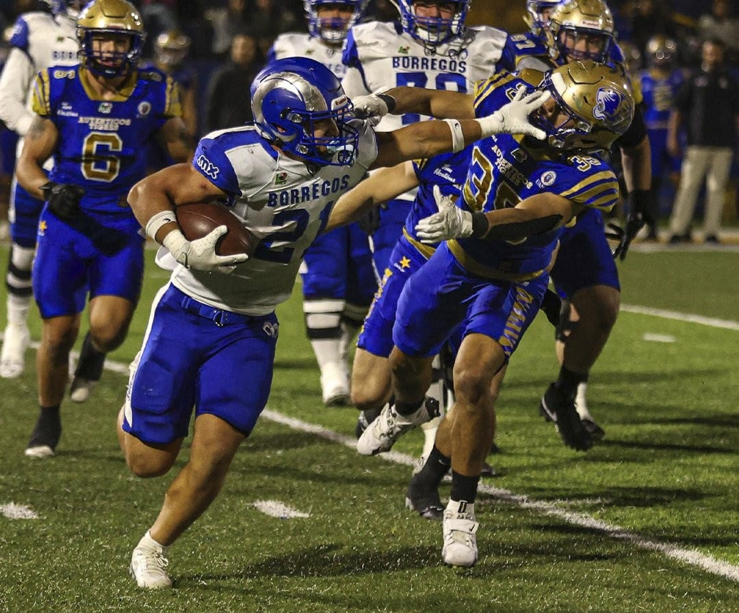 Un grupo de hombres jugando fútbol americano Descripción generada automáticamente