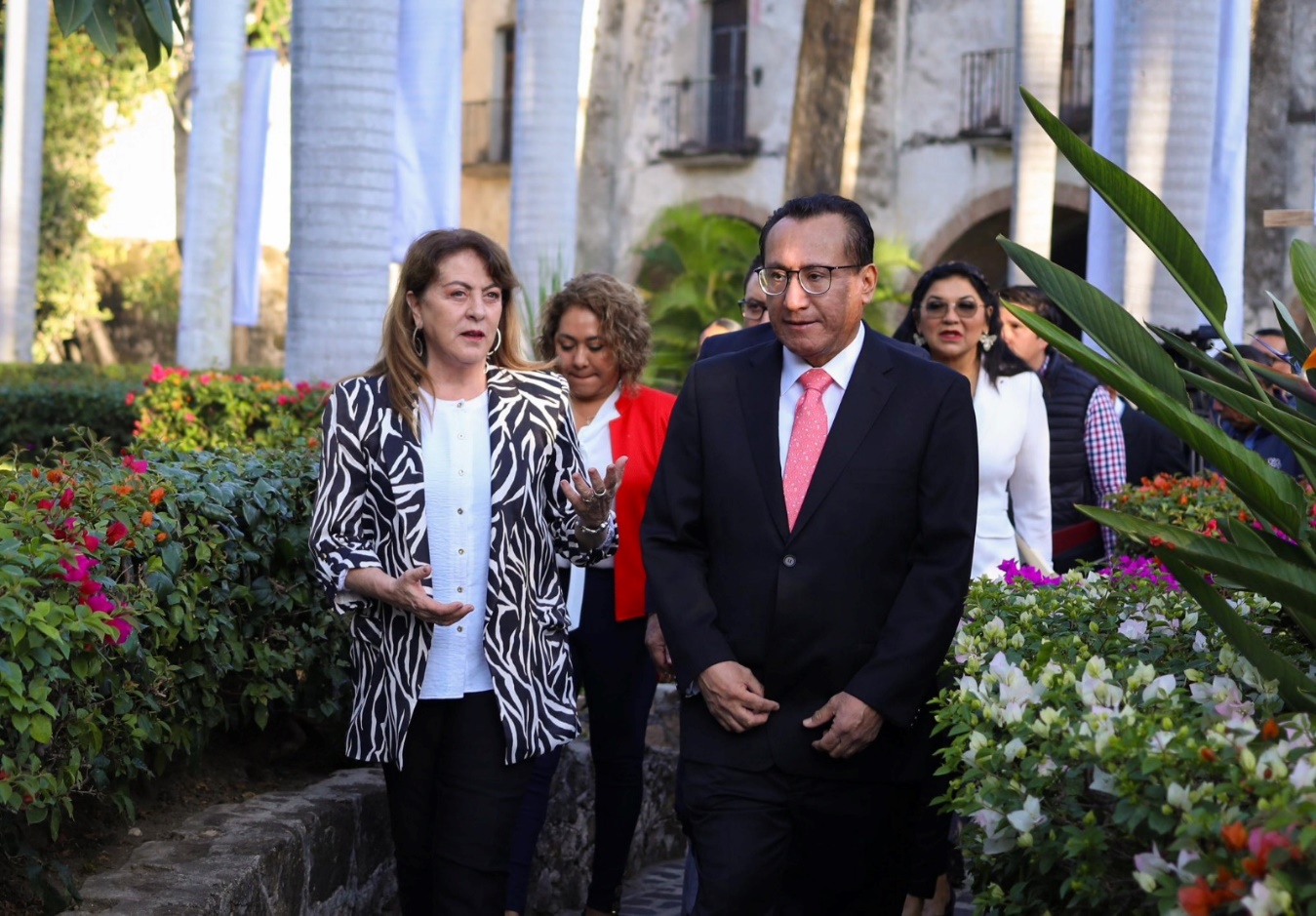 Un grupo de personas posando delante de un jardín Descripción generada automáticamente