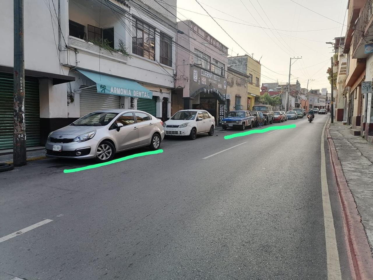 Una calle con coches y edificios de fondo Descripción generada automáticamente