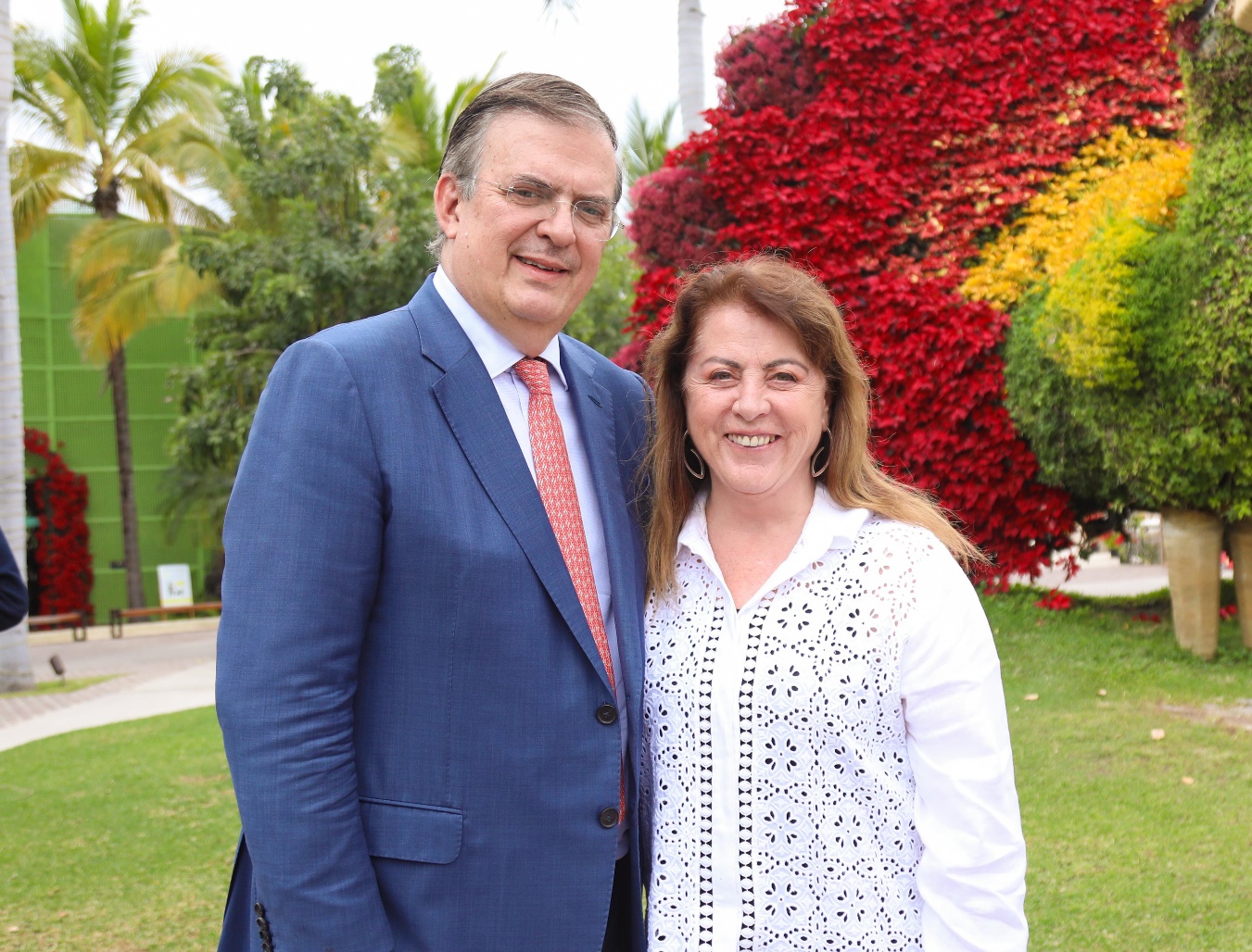Un hombre en traje parado enfrente de un árbol Descripción generada automáticamente