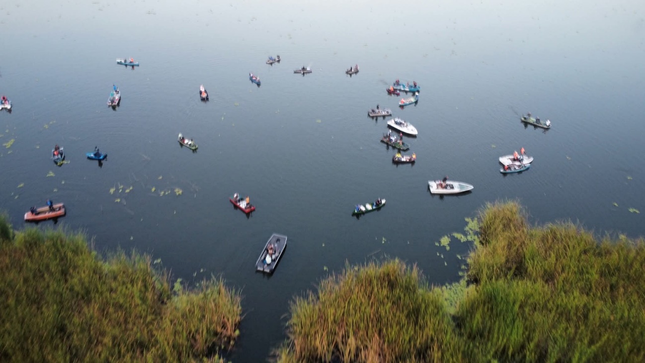 Un grupo de personas con instrumentos musicales y micrófonos en un lago El contenido generado por IA puede ser incorrecto.